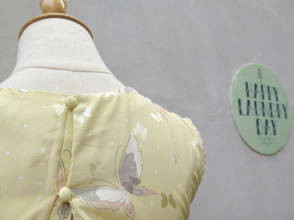 Hanamee | Vintage 1950s 1960s pastel yellow silky Dress with button back and butterfly print